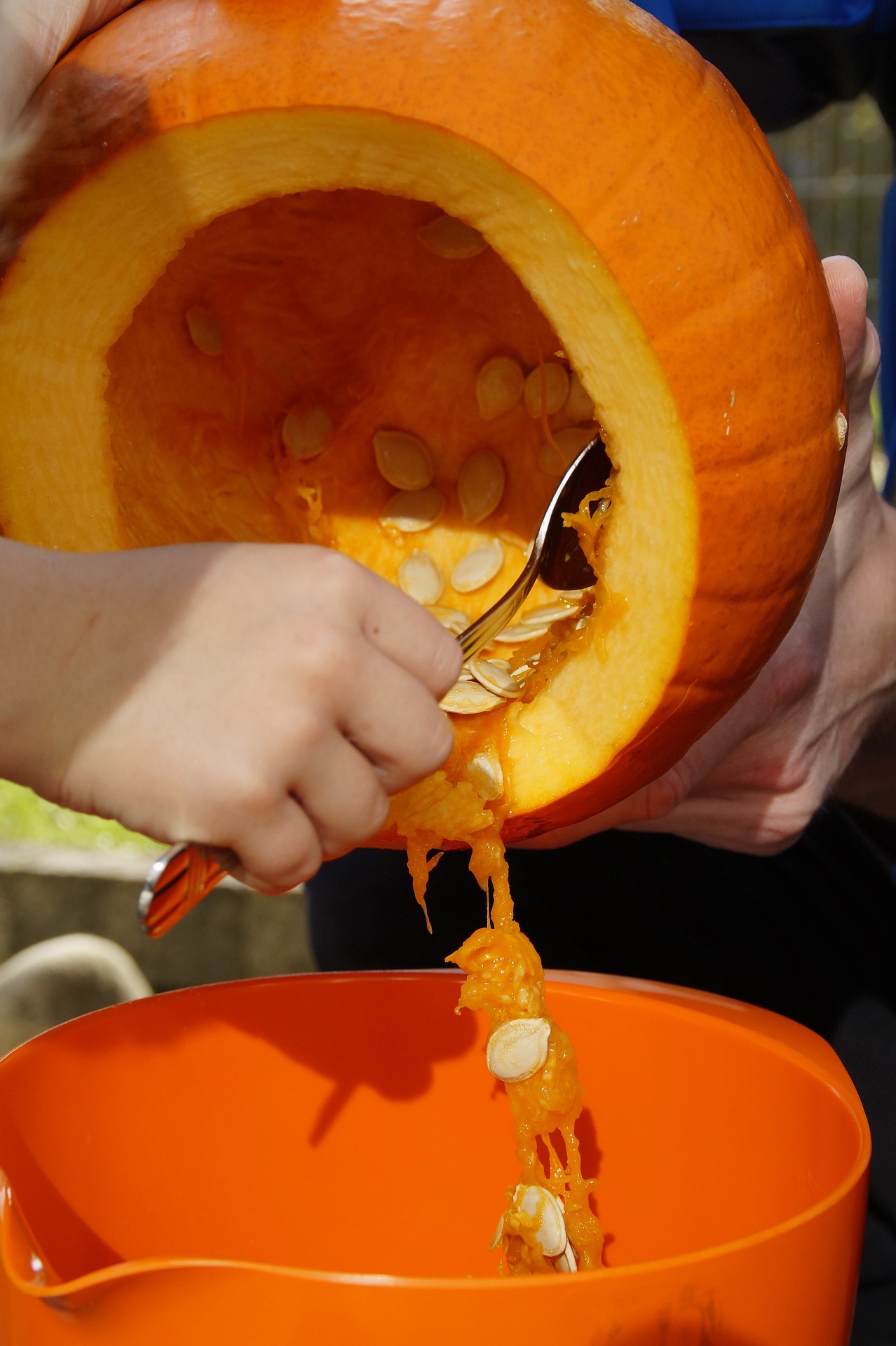 scooping out pumpkin seeds with a spoon